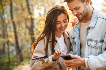 beautiful young couple in love using mobile phone