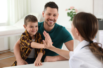 Wall Mural - Father and son visiting pediatrician. Doctor working with little patient in hospital