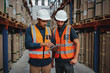 © StratfordProductions - Young focused workers in warehouse discussing work on digital tablet