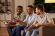 © Syda Productions - friendship, technology and leisure concept - smiling male friends with gamepads and beer playing video game at home at night