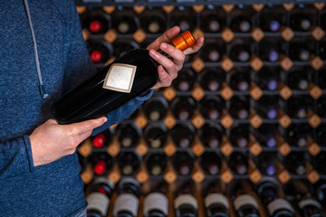 the man presents a bottle of rare wine with a screw-on closure at the taster in the show room