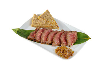 Cold appetizer before alcohol, food, marinated roast beef, fried, beef, with pickled onions and bread, slices, 7 pieces on a banana leaf, on square plate, white isolated background Side view