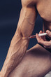 © ZaStock - Hand of a muscular man with a syringe. Doing a shot of steroids