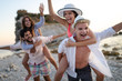 © NDABCREATIVITY - Group of friends having fun on the beach under sunset on vacation