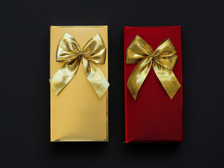 two festive gift boxes of chocolates on a black background.