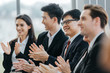 © eakgrungenerd - Business people sitting applauding speaker succesful at meeting.