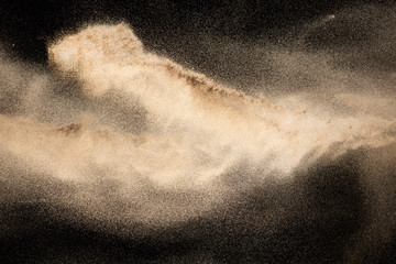 Wall Mural - Brown colored sand splash.Dry river sand explosion isolated on black background. Abstract sand cloud.