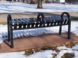 an uncomfortable park bench with a hump in the center is an example of hostile architecture