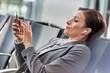 © MDBPIXS - Portrait of businesswoman listening to music on smartphone while waiting for boarding in airport