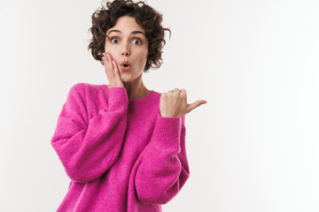 Wall Mural - Image of young woman expressing surprise and pointing finger aside