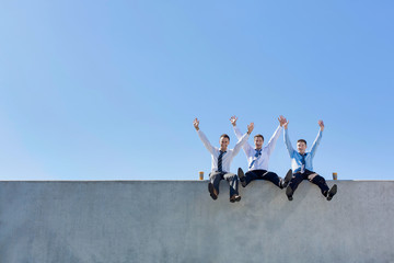 Group of handsome businessmen sitting while having fun in office rooftop