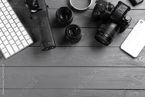 Flat lay composition with camera and video production equipment on grey wooden table. Space for text