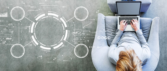 Wall Mural - Tech circle with man using a laptop in a modern gray chair