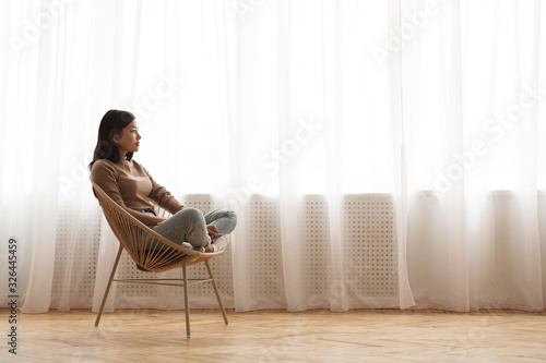Fotografía Morning harmony. Girl relaxing in wicker chair at home