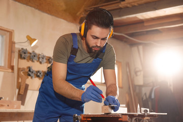 Sticker - Professional carpenter making mark on wooden bar in workshop