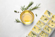© New Africa - Ice cube tray with herbs frozen in oil and fresh rosemary on grey table, flat lay
