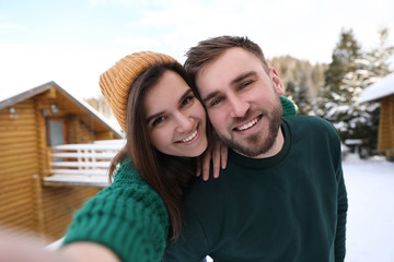 Canvas Print - Young couple taking selfie on snowy day. Winter vacation