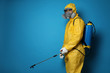 © New Africa - Man wearing protective suit with insecticide sprayer on blue background, space for text. Pest control
