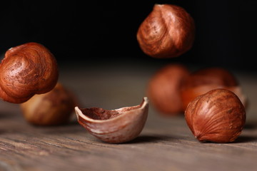 Wall Mural - tossed hazelnuts falling on a wooden table