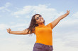 © EZ PHOTOS - Young curvy woman in a casual outfit with blue sky background