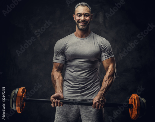 Fotografía Strong, adult, fit muscular caucasian man coach posing for a photoshoot in a dar