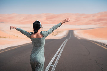 Wall Mural - Woman walking on the scenic dessert road