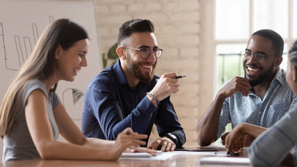 middle eastern ethnicity employee and colleagues talking sitting at desk