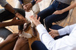 © fizkes - Diverse businesspeople talking seated on circle indoors closeup top view
