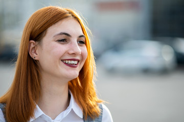 Wall Mural - Closeup face portrait of a smiling teenage girl with red hair and clear eyes.