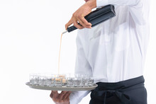Waiter Pouring Liquor Into Glass Shots On A Tray