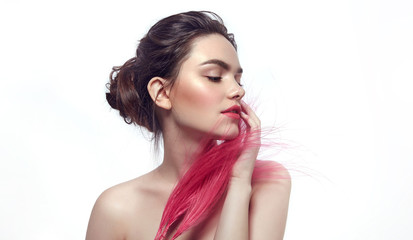 Portrait of a beautiful young tender romantic dark-haired girl on a white background. The face is covered with pink feathers.