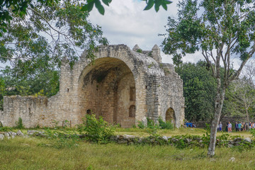 Wall Mural - Dzibilchaltun, Yucatan, Mexico: Tourists visit the ruins of a Spanish mission church built c. 1590-1600 from the stones of Mayan structures.