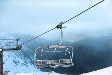 Wall Mural - ski lift in mountains, ski lift chair transports skiers and snowboards up ski field mountains