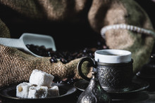 Pouring Turkish Coffee Into Vintage Cup On Wooden Background With Turkish Delight