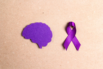 Wall Mural - Purple awareness ribbon and brain symbol on a brown background.