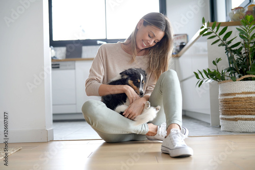 Fotografía Woman at home sittign on floor with puppy dog