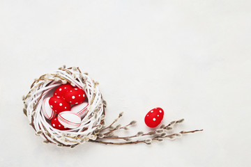 Easter background. Red and white Easter eggs in wreath on white concrete background. Top view, copy space