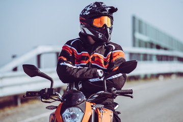 biker proud of his passion - solo motorbiker driving on an empty road  - single man trip with his motorbike