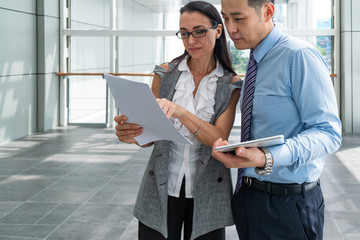 Close up portrait of smiling business people consulting using tablet and finance papers stock photo