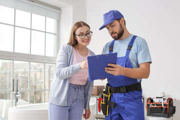 Wall Mural - Portrait of woman and plumber in bathroom