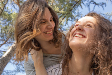 dos chicas disfrutando de una tarde primaveral en un parque lleno de almendros en flor