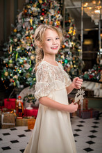 Well-dressed Little Girl At Home Dancing Around The Christmas Tree