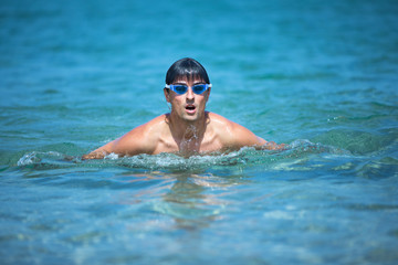 Wall Mural - Young man swimming the front crawl in the sea (swimmer, triathlon)