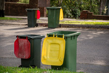 Australian Garbage Wheelie Bins With Colourful Lids For General And Recycling Household Waste Lined Up On The Street Kerbside For Council Rubbish Collection