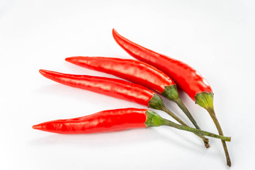 Four fresh red peppers are isolated on white background.