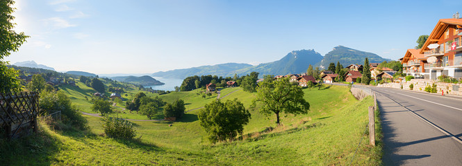 Wall Mural - idyllic tourist resort krattigen, green pasture and view to lake thunersee, switzerland