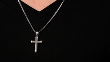 Silver Crucifix Or Cross Pendant And Necklace On Body Or Hand Studio Shot Black Color Background Which Represent To Praying For God Or Jesus For Christian Religion People Who Have Faith