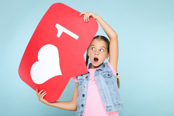 Wall Mural - Young girl holding paper card with heart and number one on blue background