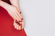 © Anna Efetova - Red beautiful manicure on red and grey stylish background with copyspace. Flat lay style.
