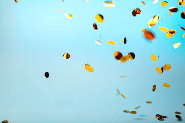 Orange and yellow falling confetti on blue background